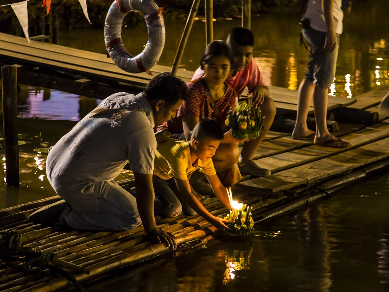 Candlelit krathongs on the water